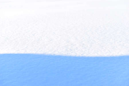 Snowy surface in winter with shadows in the eveningの写真素材