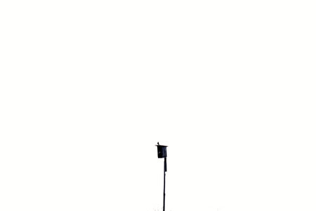 Black wooden birdhouse on white sky background
