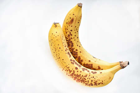 Two overripe delicious yellow bananas on a white backgroundの写真素材