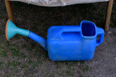 Blue plastic watering can in the garden in summerの写真素材