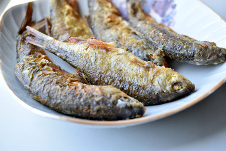 Freshly fried river fish in a plate in the kitchenの写真素材