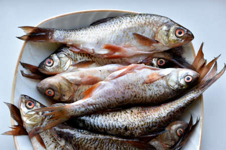 Peeled fresh river fish in a plate in the kitchenの写真素材