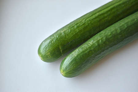 Two green long cucumbers on a white backgroundの写真素材
