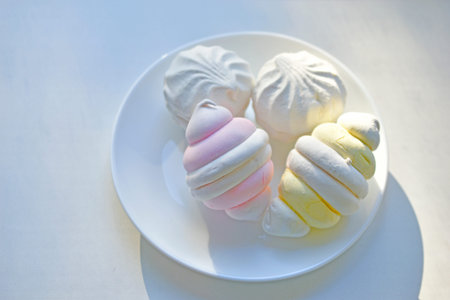 Colorful delicious marshmallows on a white plate