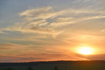 Sunset horizon with sun and clouds in the eveningの写真素材