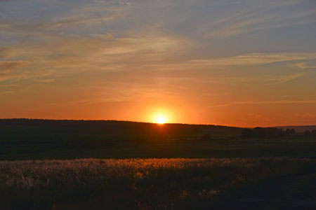 Sunset horizon with sun and clouds in the eveningの写真素材