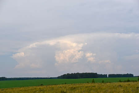 Thunderstorm landscape and cumulus clouds in the fieldの写真素材
