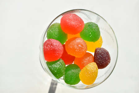 Marmalade in sugar in a glass vase on a white backgroundの写真素材