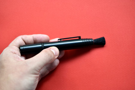 Brush for cleaning optics on a red background
