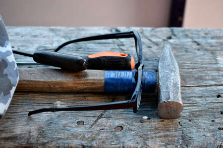 Hammer screwdriver tools and glasses on the boardの写真素材