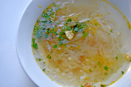 White plate with delicious noodle soup and seasonings