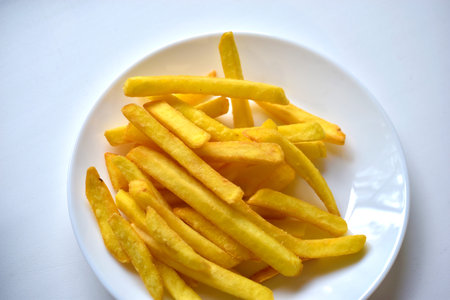 Fried French fries on a white plate close-up