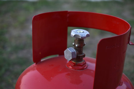 Red gas household bottle with shiny valve