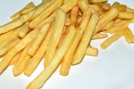 Juicy yellow delicious fries on a white plate