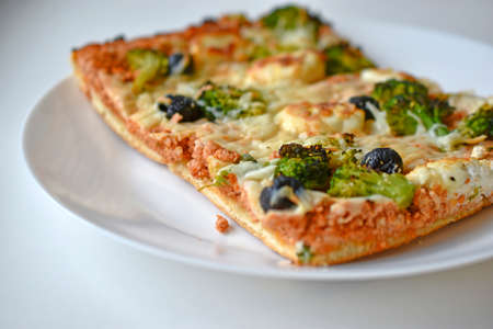 Meat pizza with greens on a white plateの写真素材