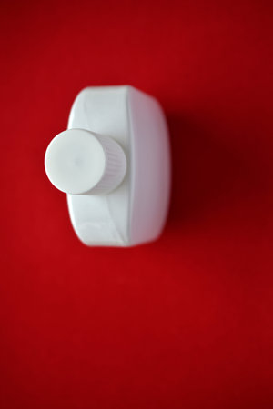 White bottle of cologne perfume on a red background
