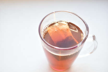 Cup mug of black hot tea with a bagの写真素材