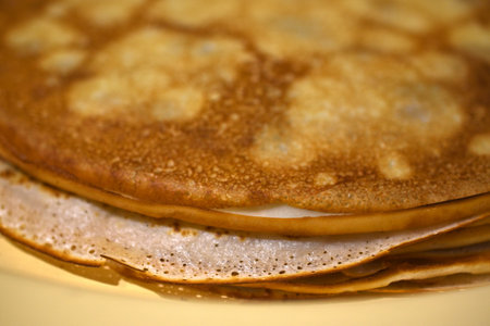 Delicious homemade pancakes on milk close-up in the kitchen