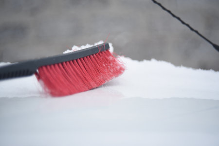 Red car brush for cleaning snow in winter in the snowの写真素材