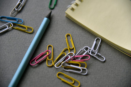 Pencils notepad and paper clips on the office desk