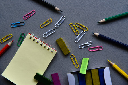 Pencils notepad and paper clips on the office desk
