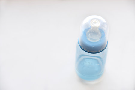 Blue baby bottle with a pacifier for waterの写真素材