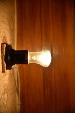 Dimly burning incandescent lamp in the roomの写真素材
