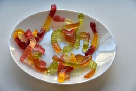 Colorful delicious marmalade snakes on a plateの写真素材