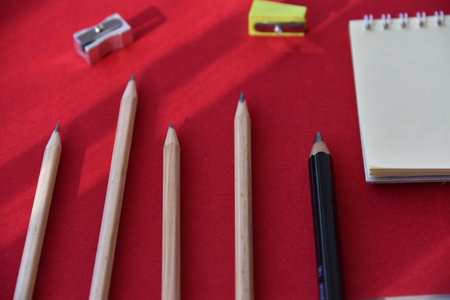 Pencils hole punch and notepad on a red background