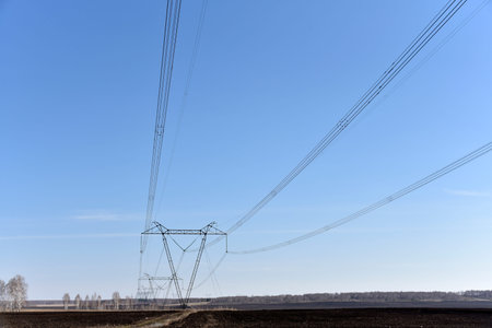 Ultra-high voltage power line in the field in spring in Russia