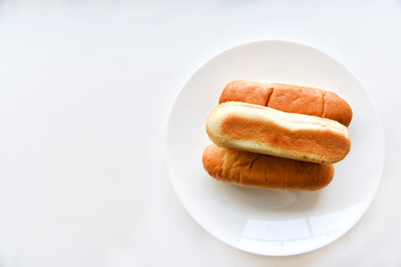 Three hot dog buns on a plate