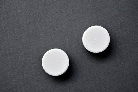 White large round tablets on a gray background. medicines.