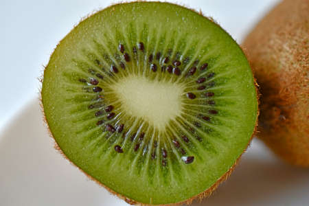 Half a green kiwi fruit on a plateの写真素材