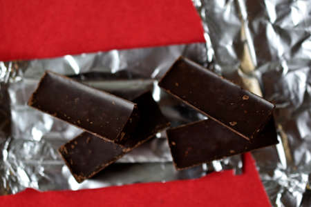 Chocolates on foil on a red background. Delicious candies.の写真素材