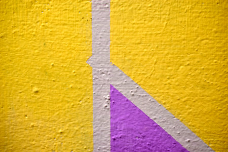 A yellow and blue wall painted with stripes and a triangle