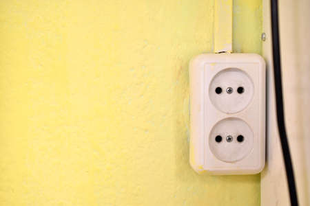 Electrical outlet on the yellow wall in the houseの写真素材