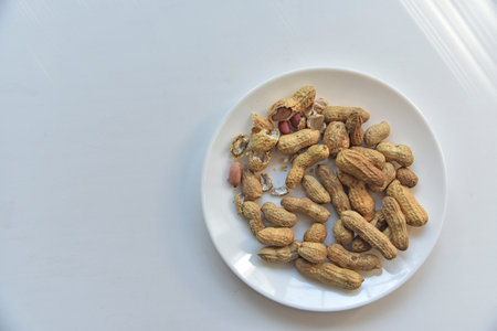Nuts peanuts in a shell on a white plateの写真素材
