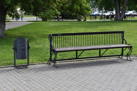 A large wooden bench in the city park in summerの写真素材