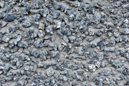 Rough concrete wall with plaster and stonesの写真素材