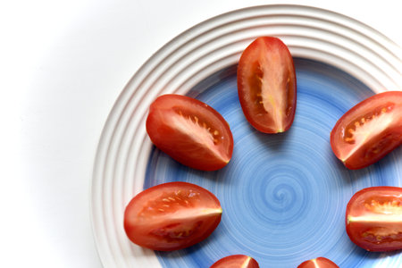 Sliced red tomato on a white plate. Vegetarian food. top view. healthy eating.