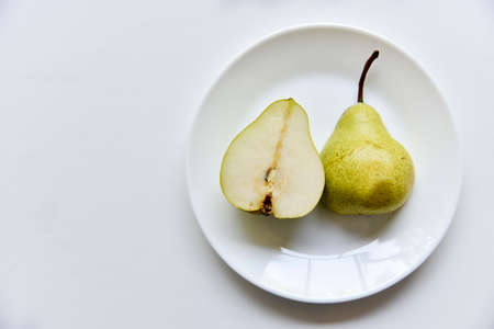 Green delicious pears on a white plate close-up.Vegetarian food.の写真素材