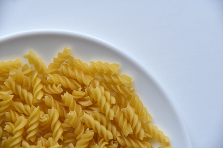 Yellow twisted raw pasta in realistic style on white background.
