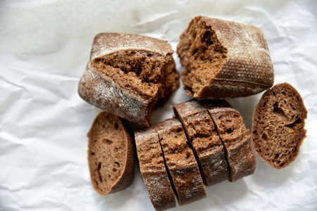 Rolls of rye black bread on white paper. french breakfast. gourmet food.
