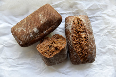 Rolls of rye black bread on white paper. french breakfast. gourmet food.の写真素材