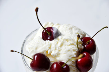 Creamy sweet ice cream in a glass ice cream maker with large cherry berries. isolated object.