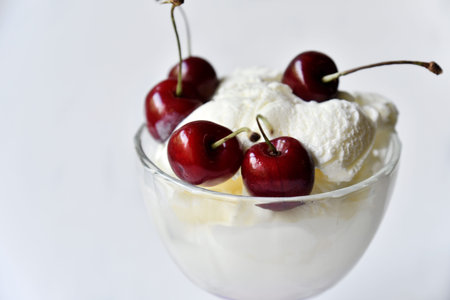 Creamy sweet ice cream in a glass ice cream maker with large cherry berries. isolated object.