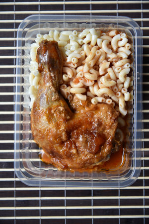 Fried chicken leg garnish with gravy and vermicelli. Delicious meat lunch in a container. gourmet food. healthy meals.の写真素材