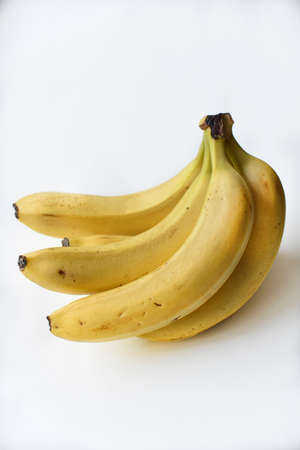 Ripe yellow banana on a white background. A bunch of fresh bananas. Sweet bananas for breakfast. Vegetarian food.の写真素材