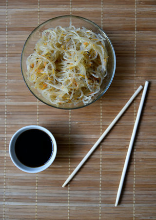 Korean rice noodles with meat and spices in a glass bowl. Delicious noodles with meat and spices....