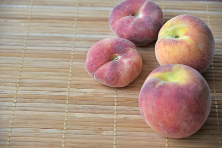 Juicy delicious peaches close-up on a mat. Vegetarian food.